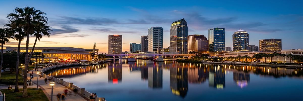 Tampa, Florida skyline along the Hillsborough River at dusk with downtown buildings reflected in calm water